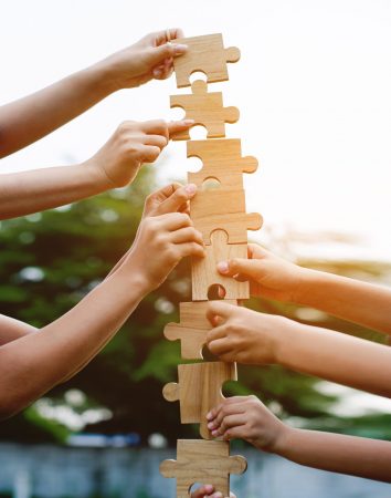 Jigsaw puzzle in hand, teamwork together communication puzzle piece teamwork concept